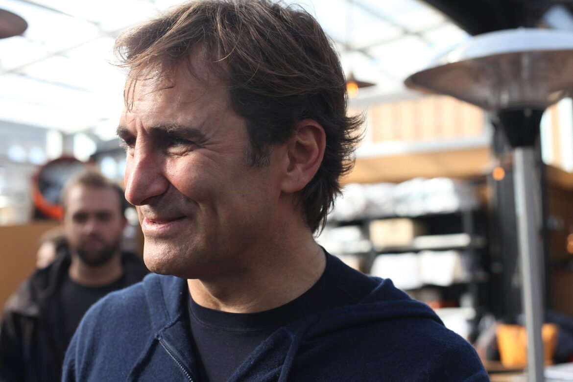A close-up portrait of Alex Zanardi laughing, capturing his infectious optimism and the strength of spirit that has motivated thousands of people worldwide.